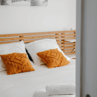 chambre avec coussins jaune moutarde dans une location saisonnière gérée par conciergerie ty anne